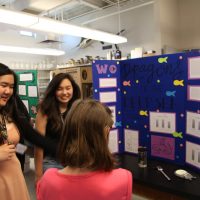 A group of people stand around a presentation board.