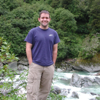 Eric standing on the bank of a river near Franz Josef Glacier