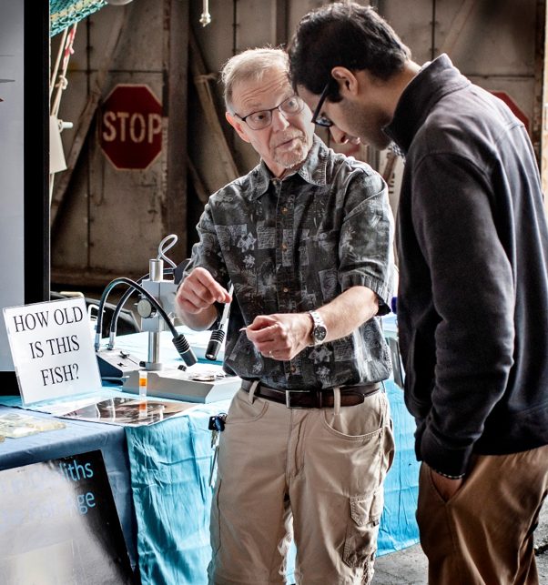 Craig describes otoliths at a National Oceanic and Atmospheric Administration, Alaska Fisheries Science Center open house. 