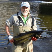 Orlay holding a coho salmon at the UW hatchery in 2008