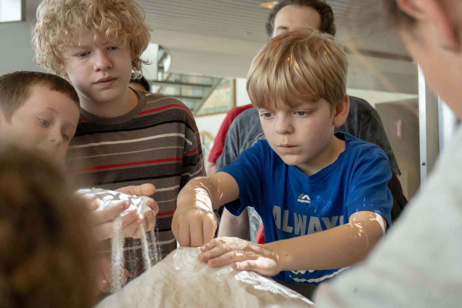 A group of children holding sand during the UW Aquatic Sciences Open House.