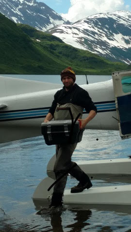 Lukas loading gear off a plane in Alaska