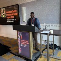 Ashley stands behind a podium when delivering a presentation at a conference.