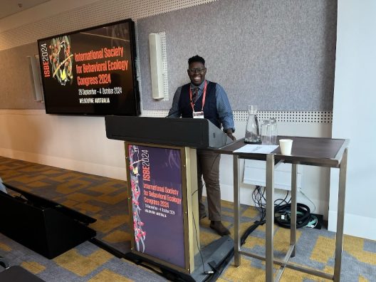 Ashley stands behind a podium when delivering a presentation at a conference.