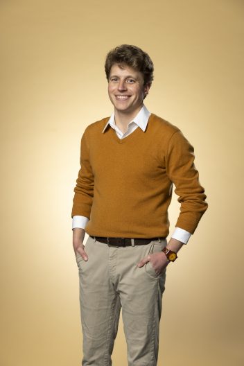 Callum stands smiling into the camera for his Husky 100 portrait.