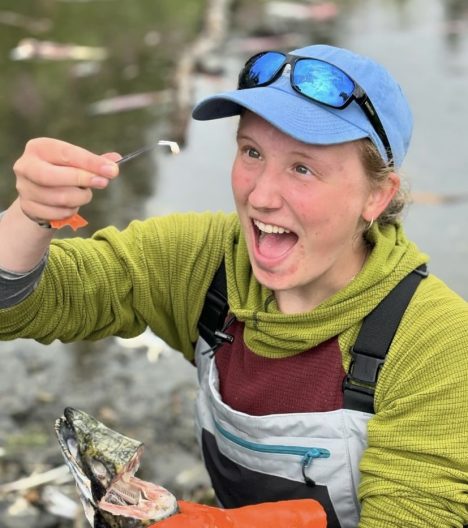 Naomi Prahl smiles as she collects an otolith from a fish in Alaska.