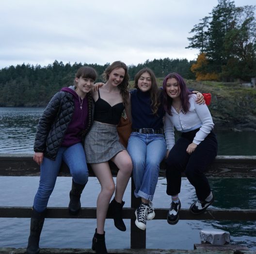 Four students sit on the boat dock at Friday Harbor Labs.