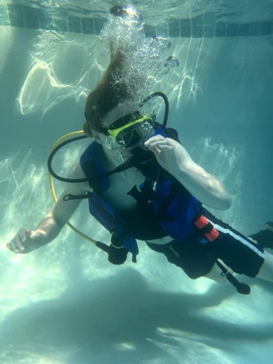 Jasper Nevis underwater in a pool with diving gear.